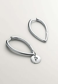Pendientes de aro de plata con forma de lágrima, que presentan un pequeño charm redondo con una letra "P" en relieve. Superficie de metal lisa y acabado pulido.