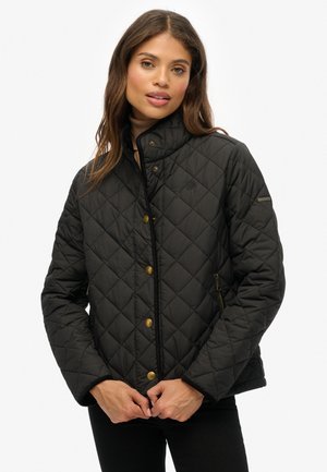 Chaqueta negra acolchada con cuello alto, con botones en tono dorado y bolsillos laterales con cremallera, hecha de un material suave y resistente al agua.