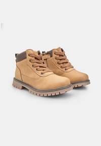 Stivali alla caviglia in pelle tan con dettagli marroni, design con lacci e suola in gomma con battistrada a motivo per una migliore aderenza.