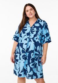 Marineblaues Kleid mit großem hellblauem Blumendruck, kurzen Ärmeln und V-Ausschnitt. Aus leichtem Stoff gefertigt. Lässiger Schnitt.