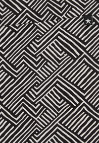 Čierno-biely textil s geometrickým vzorom z hrubých a tenkých čiar usporiadaných do labyrintového dizajnu s rôznymi tvarmi.