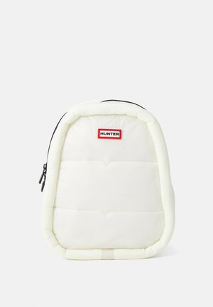 Mochila blanca acolchada con forma redondeada, cremallera negra, logo "HUNTER" en rojo y negro, y sutil textura acolchada.