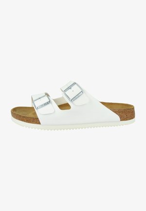 White two-strap sandal with adjustable silver buckles, cork footbed, and white rubber sole. Smooth finish with a flat design.