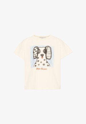 T-shirt à manches courtes couleur crème avec une illustration de dalmatien dessinée et le texte "Bobo Choses" en orange sous le chien.