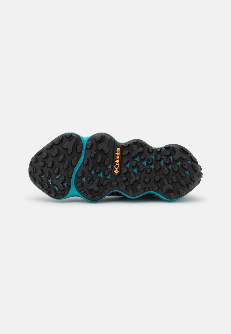 Semelle de chaussure noire et turquoise avec un motif de grip texturé, présentant des formes hexagonales et un logo Columbia orange bien visible.