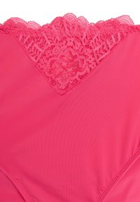 Roza spodnje perilo z nazobčeno čipkasto obrobo na vrhu, gladkim materialom in nežnim šivom ob robovih.