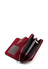 Červená kožená peněženka se zipovým uzávěrem, se sloty na karty, průhledným okénkem na identifikaci a vyraženým vnitřním vzorem ve tvaru cik-cak.