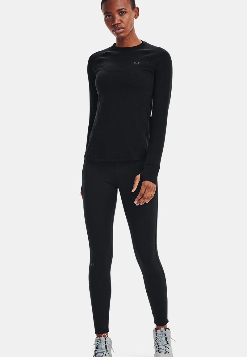 Zwarte lange mouwen sportshirt en aansluitende leggings, gemaakt van lichtgewicht stof, met een soepele textuur en subtiele logo-detail.