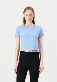Tricou scurt de culoare albastru deschis, din bumbac, cu guler rotund și mâneci scurte, având un mic logo "HUGO" brodat în centru.