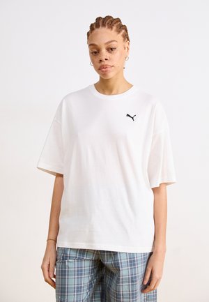 White cotton t-shirt with short sleeves, featuring a black Puma logo on the left chest. Paired with blue plaid pants.
