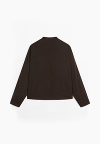 Brun langærmet skjorte med rund krave, der har lige snit og synlig sømdetalje på ryggen. Glat tekstur.
