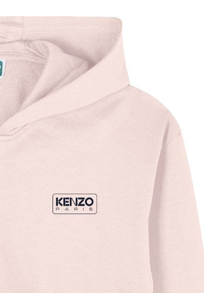 Hoodie rose clair avec un petit logo noir "KENZO PARIS" sur la poitrine gauche et une capuche décontractée repliée au niveau du col.