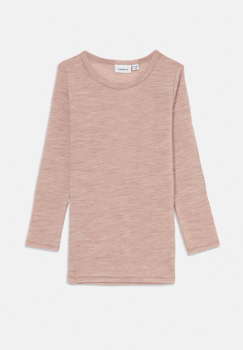 Langermet, lys rosa topp laget av ribbet stoff. Har rund hals og rett hem. Ingen synlige mønstre eller utsmykninger.