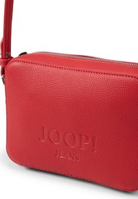 Röd läderaxelväska med en strukturerad yta, som har en präglad logotyp och silverfärgat spänne, samt en dragkedja. Kompakt rektangulär form.