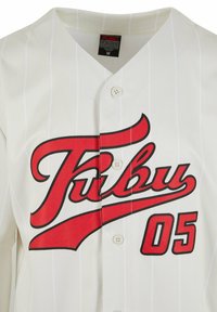 Un maillot de baseball blanc avec le texte rouge "FUBU" et le numéro "05". Il présente des rayures verticales, un système de fermeture à boutons et un col en V.