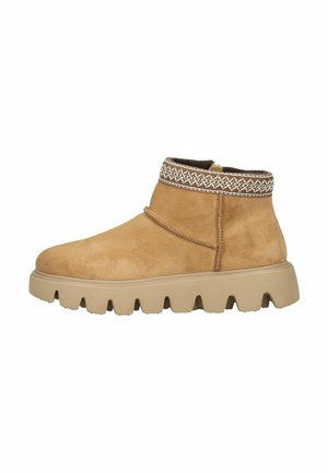 Bottine en daim beige avec un col texturé présentant des coutures décoratives, semelle en caoutchouc avec des crampons prononcés pour une meilleure traction.