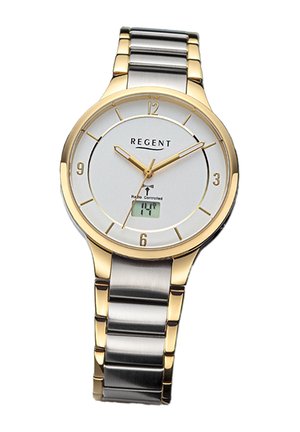 Montre-bracelet dorée et argentée avec un cadran blanc, des chiffres arabes et un affichage numérique à 6 heures. Elle possède un bracelet en acier inoxydable.