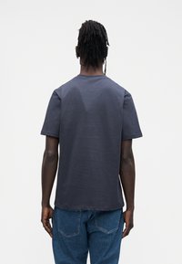 Granatowy t-shirt z krótkim rękawem i okrągłym dekoltem, wykonany z gładkiej bawełny, o prostym kroju i minimalistycznym wzornictwie.