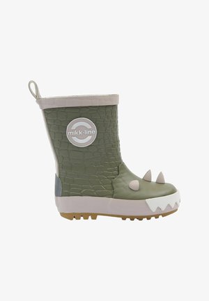 Botte de pluie pour enfants en caoutchouc vert avec texture crocodile, accents en forme de crocs blancs, bordure beige et logo circulaire de la marque.