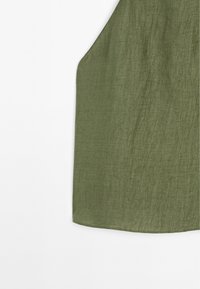 Haut sans manches en tissu texturé vert avec un ourlet arrondi sur fond blanc.