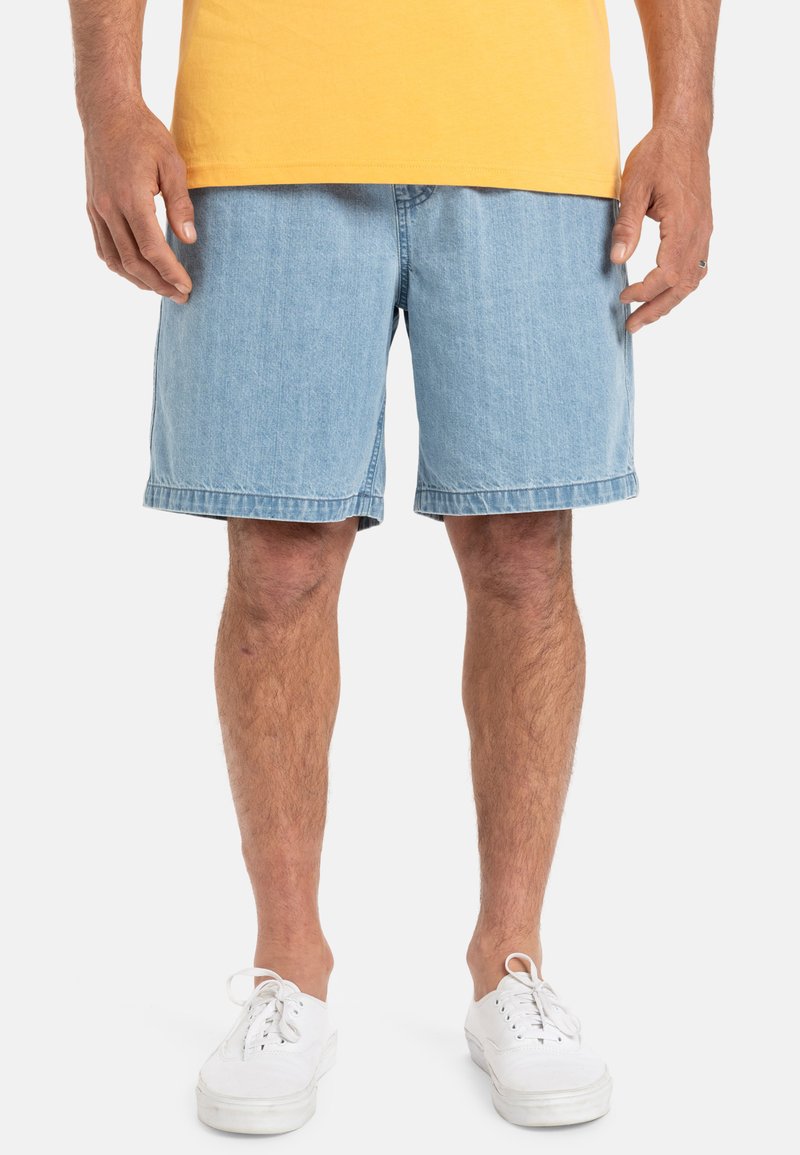 Lichte blauwe denim shorts met een relaxte pasvorm, een rafelige zoom en zijzakken, gecombineerd met witte vetersneakers.