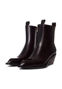 Bottines en cuir marron avec un bout pointu, une fermeture éclair sur le côté et deux pattes de tirage. Dotées d'un talon empilé et d'une texture lisse.