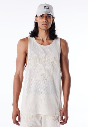 Top sin mangas de malla beige con "NEW ERA" y "20" en relieve en texto grande. Combinado con una gorra gris claro con un logo en blanco y negro.