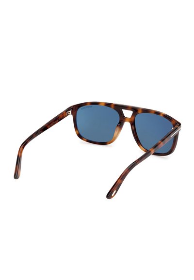 Rektangulære solbriller i skildpaddemønster med blå linser og en karakteristisk udskåret bro, vist fra en bagerste tre-kvart vinkel.