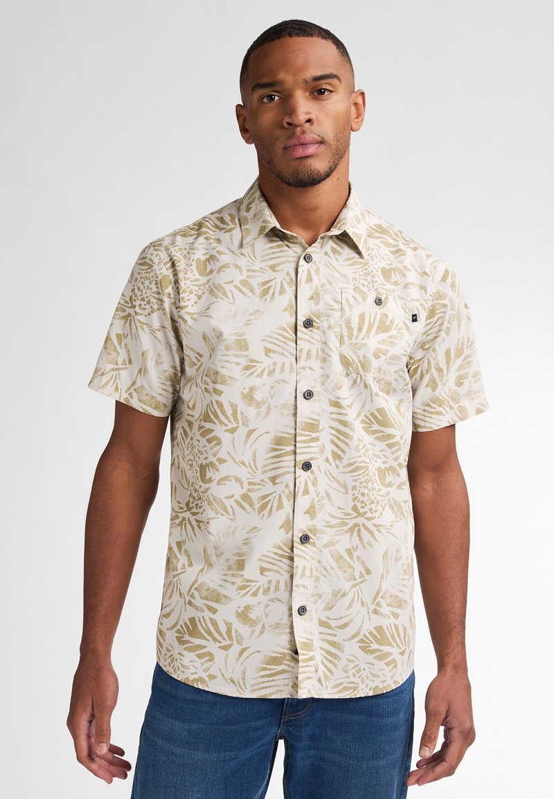 Camisa de manga corta con botones en beige claro con un estampado de hojas tropicales en crema y dorado. Presenta un bolsillo frontal y botones oscuros.