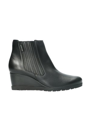 Bottine en cuir noir avec talon compensé, panneau latéral élastique côtelé et semelle en caoutchouc, adaptée pour un usage décontracté ou formel.