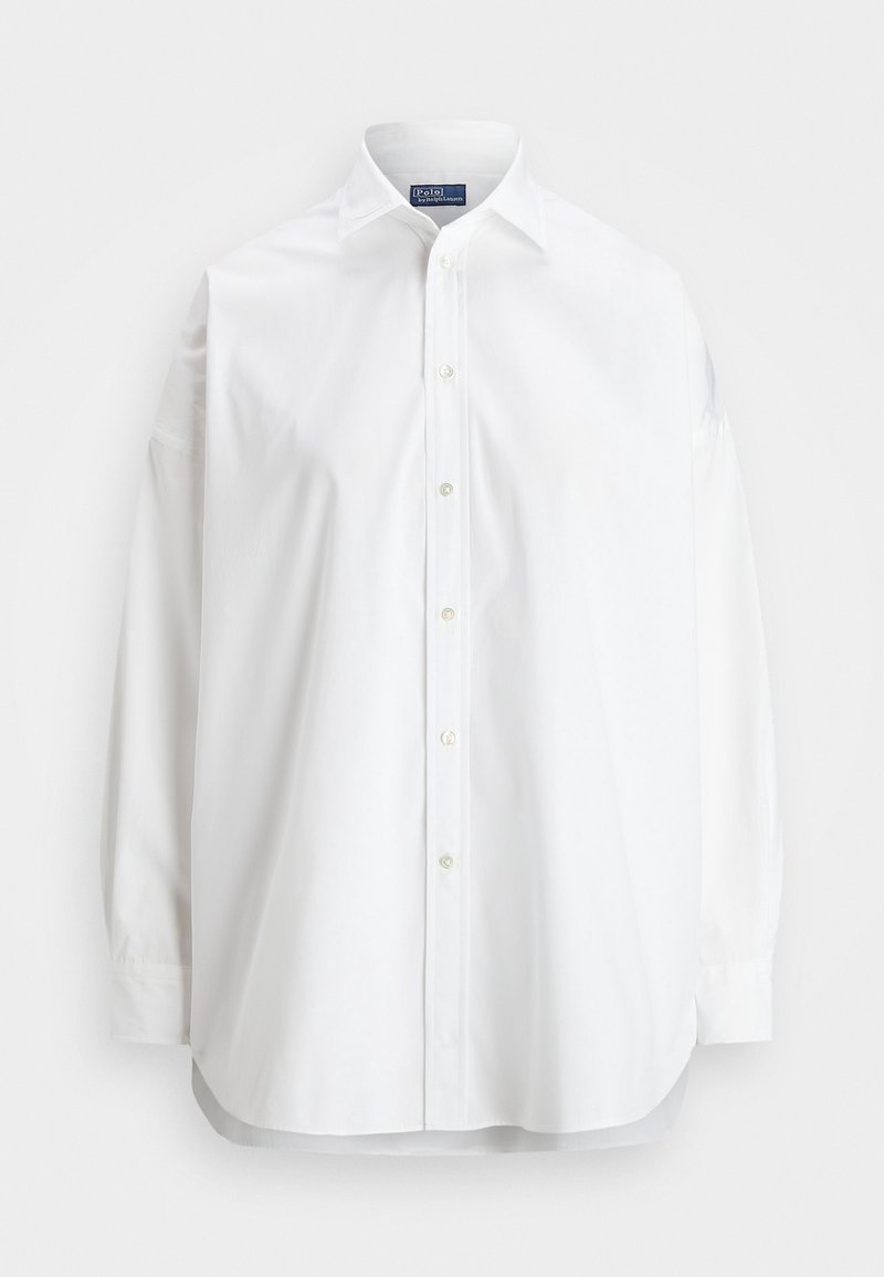 Chemise blanche à manches longues avec boutons, col classique, boutons visibles sur le devant et étiquette Polo by Ralph Lauren à l'intérieur du col.