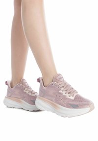 Baskets en maille roses avec une tige texturée, semelles blanches rembourrées et lacets coordonnés. Présente un logo de marque proéminent sur la languette.