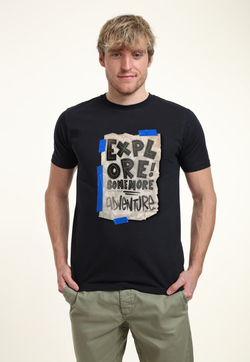 Černé tričko s velkým grafickým motivem zmuchlaného papíru se modrou páskou. Text zní "PROZKOUMEJ! JEŠTĚ VÍC DOBRODRUŽSTVÍ" tučným písmem.