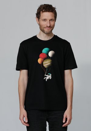 Zwart katoenen t-shirt met een kleurrijke afbeelding van planeten en een astronaut die ballons vasthoudt. Korte mouwen en een standaard pasvorm.