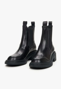 Czarne skórzane botki chelsea z elastycznymi panelami bocznymi, okrągłym noskiem i masywną gumową podeszwą. Wyposażone w pętle do łatwego zakładania.