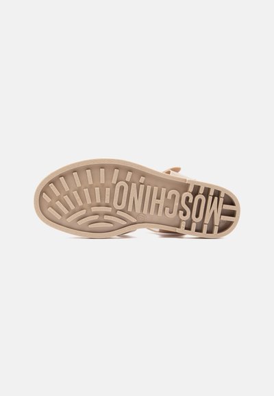 Semelle de sandale beige avec un motif de crampons profonds et le nom de la marque "MOSCHINO" embossé sur la semelle, présenté sur fond blanc.
