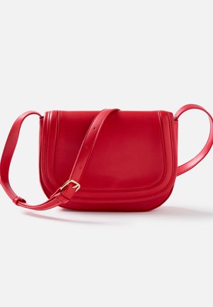 Rode leren crossbodytas met een gebogen klep en verstelbare band met een gouden gesp, getoond tegen een witte achtergrond.