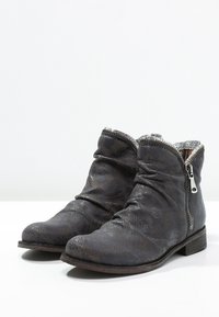 Botas tobilleras de cuero gris oscuro con un patrón texturizado, diseño desgarbado, cierre con cremallera plateada y un tacón bajo de madera.