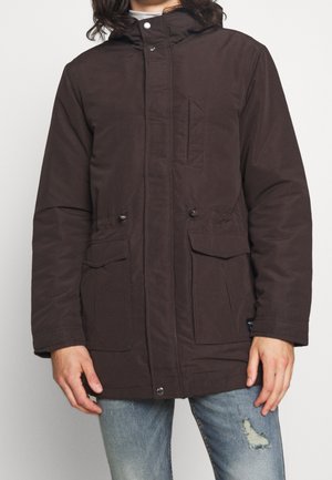 Brun isolerad parka-jacka med huva, med framknäppning, två stora sidofickor och en bröstficka med vertikal sömdetalj.
