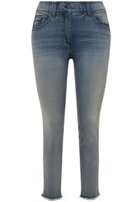 Vaqueros de mezclilla en un color azul desgastado, con un diseño ajustado, cintura elástica, cinco bolsillos y dobladillos desgastados en los tobillos.