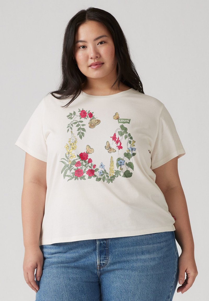 Cream-colored short-sleeve t-shirt featuring floral and butterfly embroidery. Levi's logo tag stitched on the upper left. Cotton material.