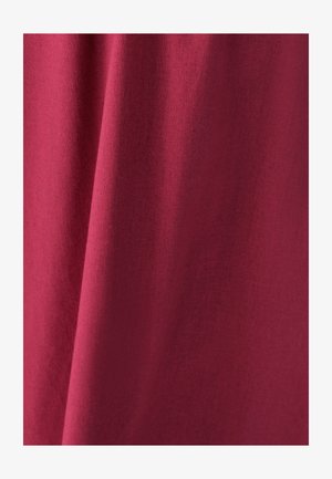 Tummanpunainen puuvillakangas, jossa on sileä pinta ja hienovarainen heather-kuvio. Pehmeä laskeutuminen. Ei näkyviä saumoja tai koristuksia.