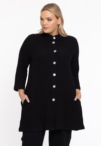 Zwart, button-up jurk met een textuurstof, kraag, driekwartmouwen en zijzakken. Bevat grote zilveren knopen.