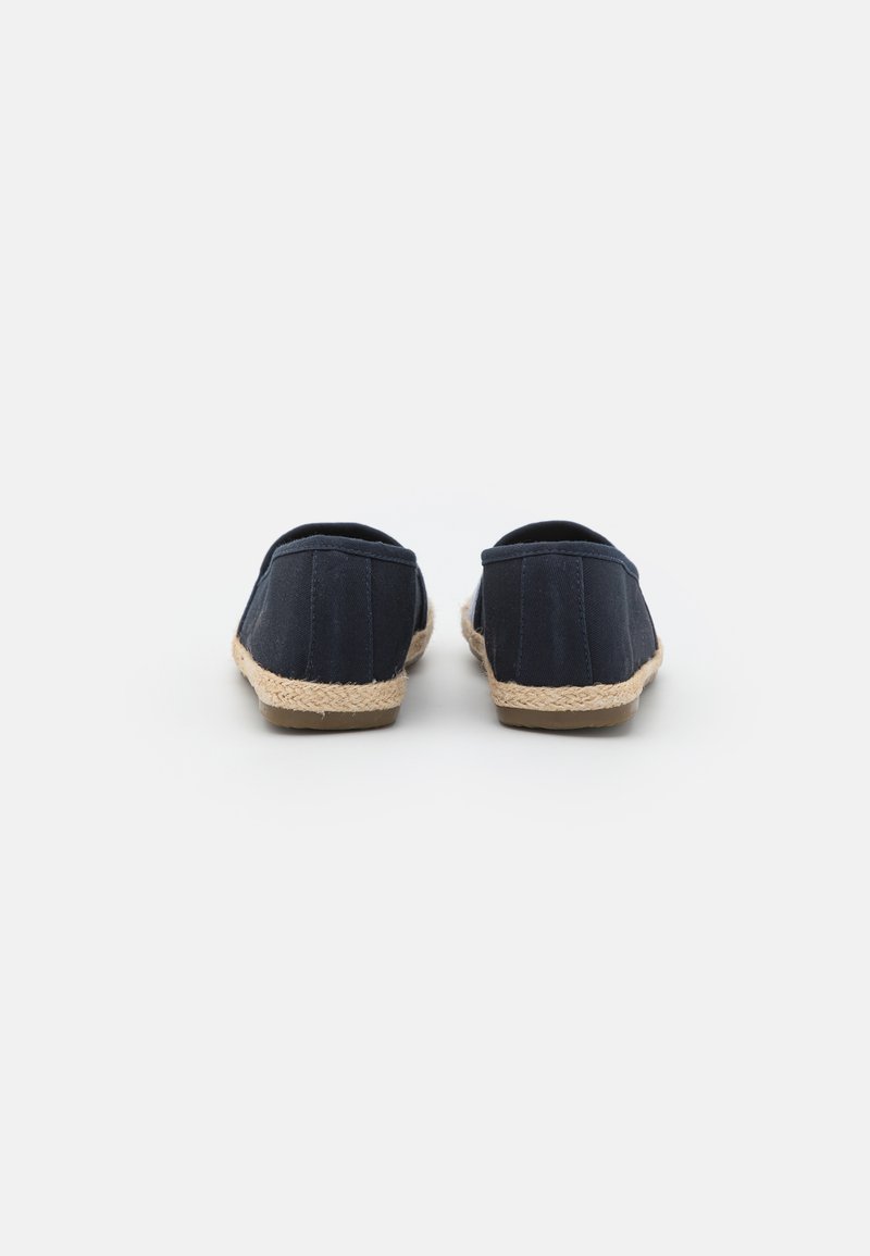 Ein Paar dunkelblaue Leinen-espadrilles mit sohlen aus natürlichem jute-seil, von hinten auf einem weißen Hintergrund betrachtet.
