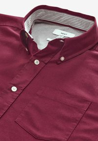 Bordeauxfarbene Button-Up-Hemd mit einem kontrastierenden gestreiften Kragen. Verfügt über eine Einzelbrusttasche und weiße Knopfverschlüsse. Baumwollmischgewebe.