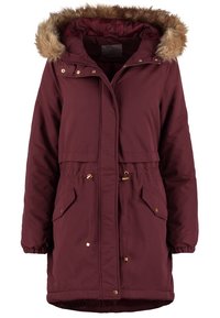 Long manteau d'hiver bordeaux avec capuche bordée de fausse fourrure marron clair, fermeture éclair à l'avant, boutons pression, taille avec cordon de serrage et deux poches avant à rabat.