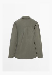 Oliven grøn langærmet skjorte, knap-ned krave, detalje med pleat på bagsiden, blødt stof, lige kant, knapper ved mansjetterne, letvægtsdesign.