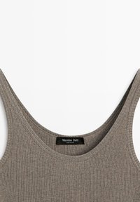 Beige geribbelde mouwloze tanktop met een ronde halslijn en een zwart Massimo Dutti-label dat aan de binnenkant van de achterste kraag is genaaid.