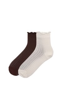Bomullsgympestrumpor i mörkbrunt och vitt, med en strukturerad ribbadDesign och en scalloped toppkant.