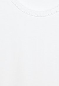 Camiseta blanca con un escote redondeado y bordes acanalados, y pequeños acentos de puntos. Tejido suave y liso con una textura sencilla.